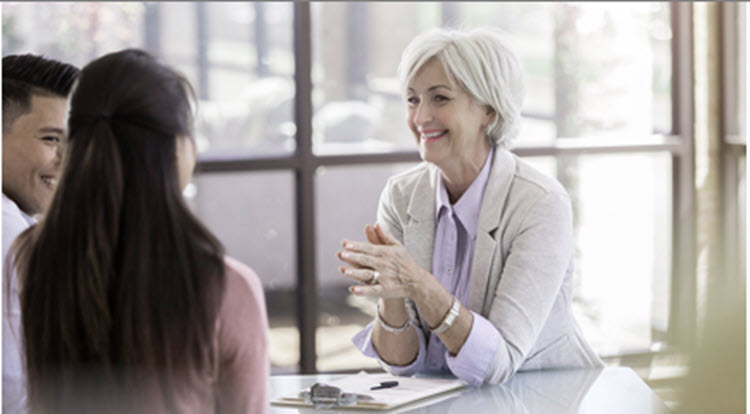 Woman discussing life insurance with couple.