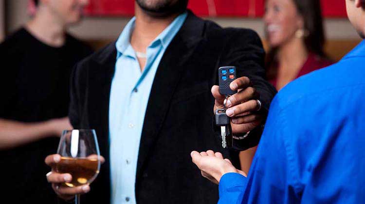 Man with wine glass handing over car keys.