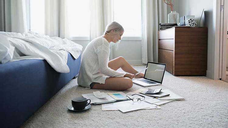 Woman reviewing balance transfer offers on her tablet with her daughter sitting in her lap