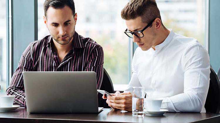 Two men at a laptop.