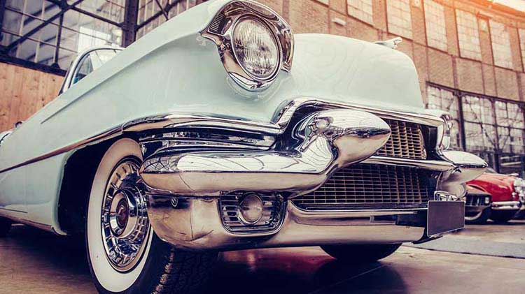 Vintage automobile on a classic car dealership lot.