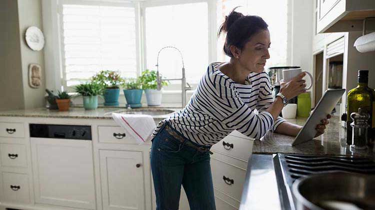 Woman on a tablet reading about the benefits of a roth ira conversion.