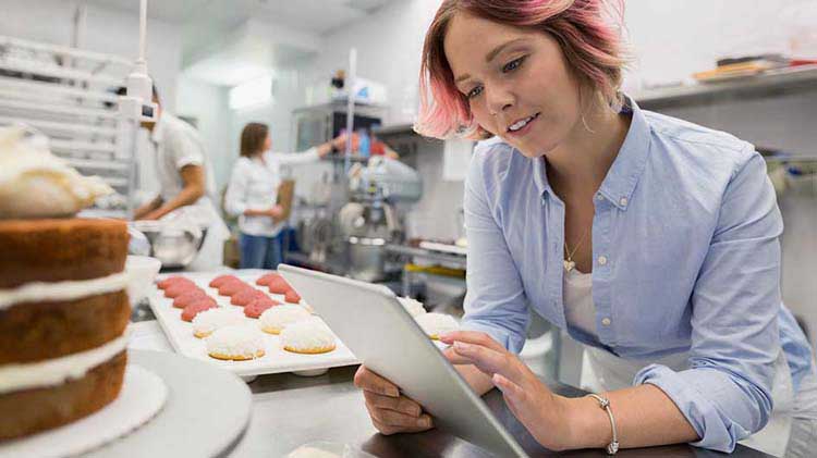 Bakery owner checking out small business retirement plans on an iPad.