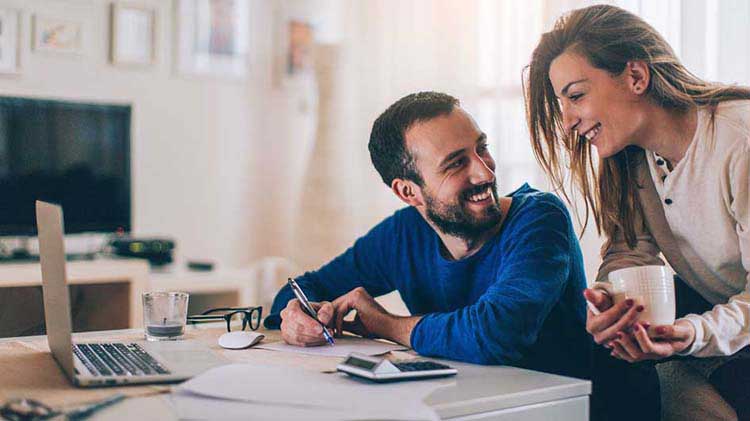 Couple talking and budgeting at laptop.