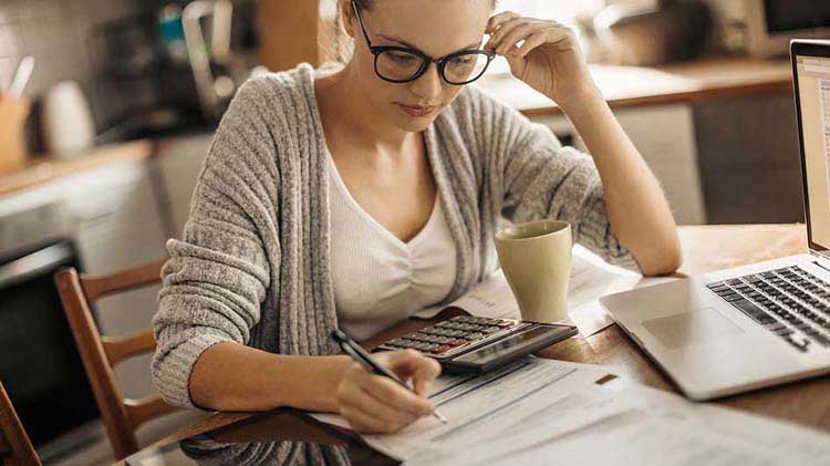 Woman working with calculator and laptop