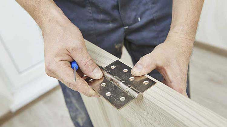 Man installing a door hinge.