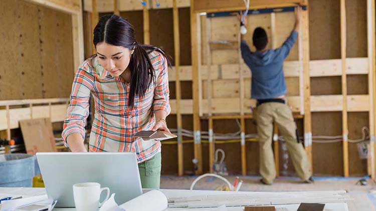 Couple putting up walls in a house.