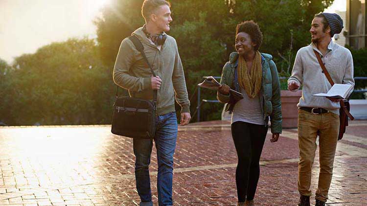 Three college students walking on campus.