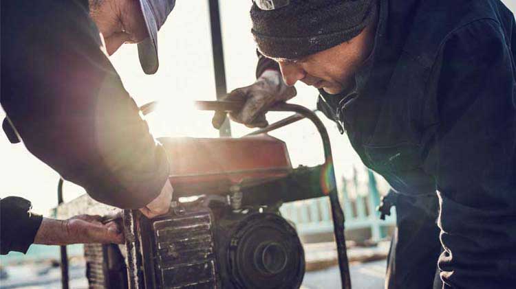 Two people working on a portable generator.