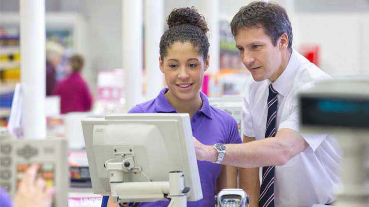 A man explains a credit card transaction to a teen.