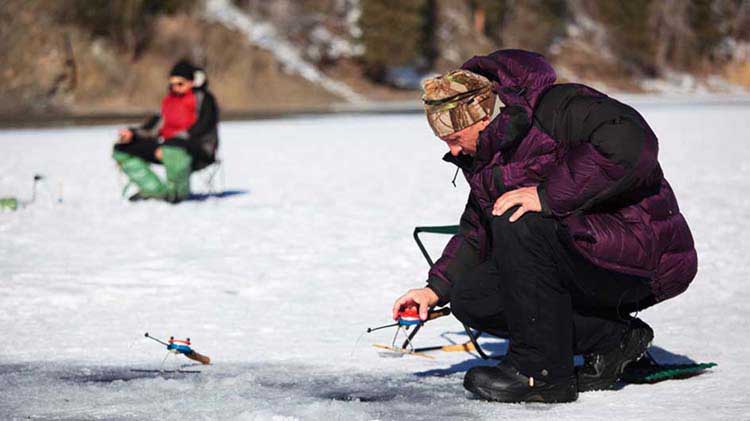 Two people ice fishing.