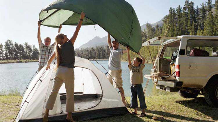 Family setting up a tent for camping.