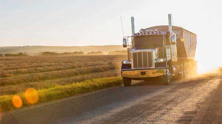 Truck driving past a field