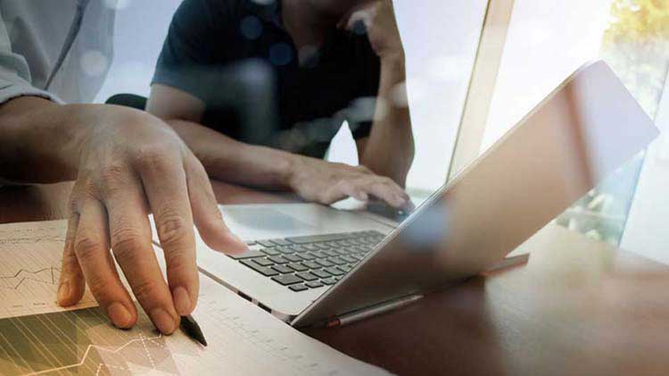 Two people looking at a laptop.