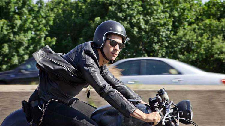 Man with a helmet riding a motorcycle.