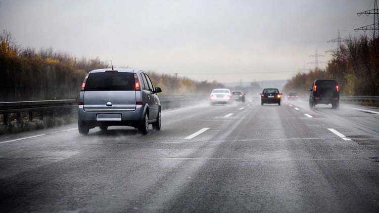 Vehicles carefully driving on black ice.