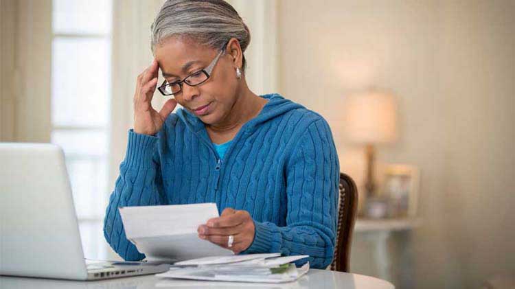 Mature woman studying a document related to Medigap plans.