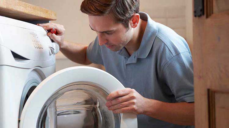 A man performing washing machine maintenance.