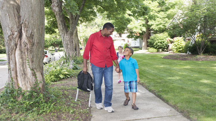 Adult and child walking to school safely.