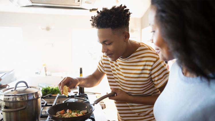 Adult child helping mom cook a meal.