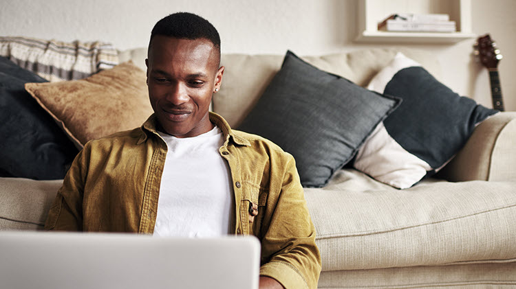 Man working on his laptop researching how to buy a car online.