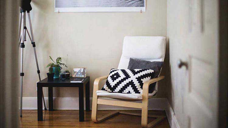 Entrance of an apartment with furniture and a camera tripod, all covered by the tenant's renters insurance.