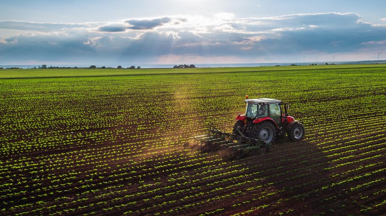 Tractor cultivating a field at spring, aerial view.