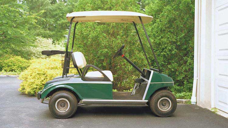 Golf cart parked in front of a garage.