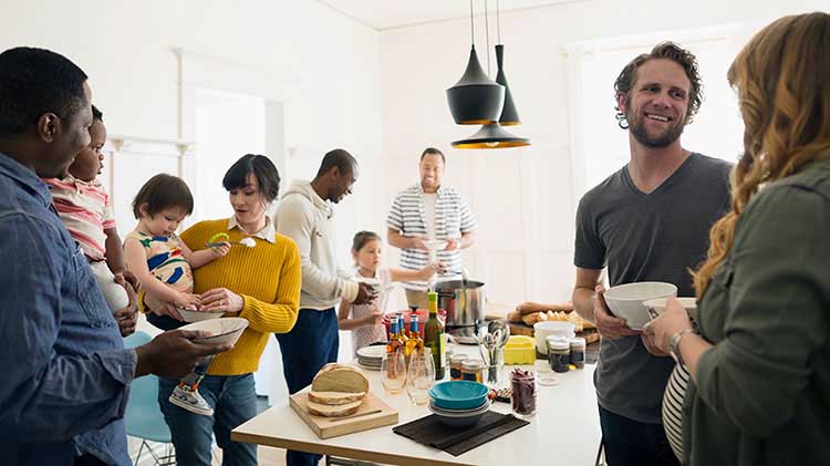 Friends at a house party talking in the kitchen