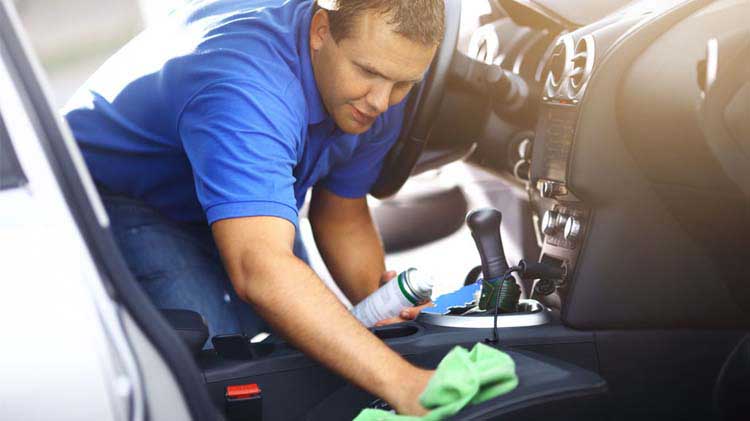 A man cleaning the interior of his car.