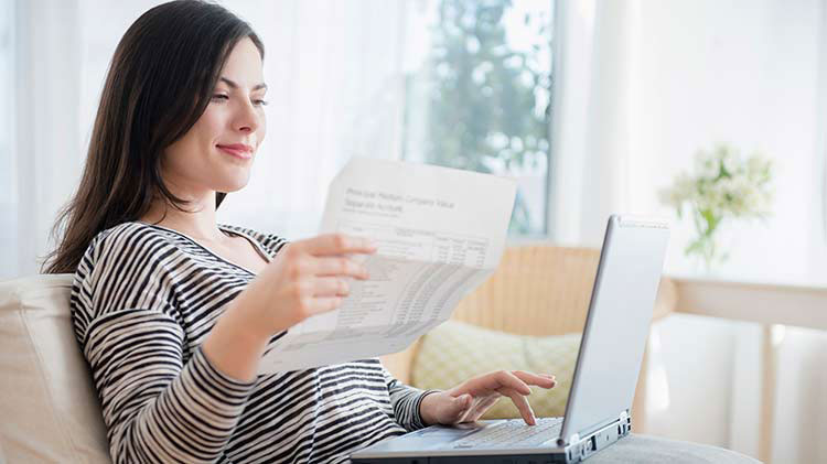 Woman creating a budget and managing expenses on her laptop.