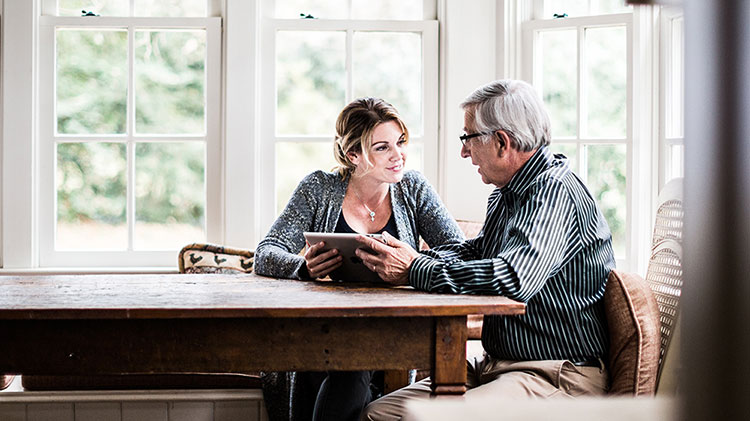 Woman working on a tablet with her father.