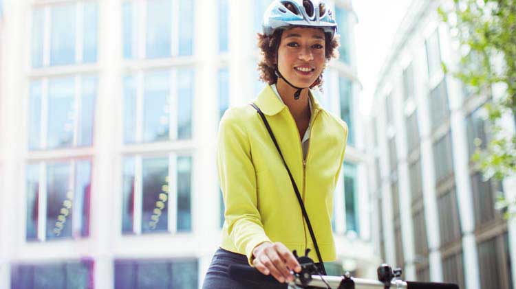 A woman going to work by bicycle and with a helmet on her head