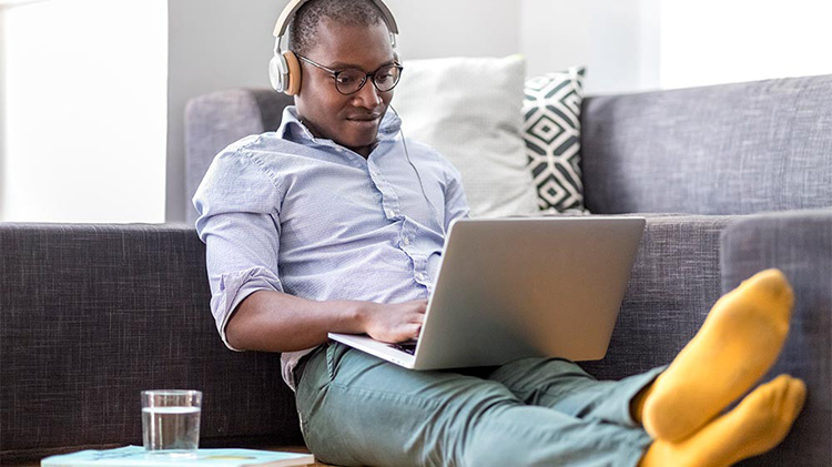 A millennial aged man working on his laptop