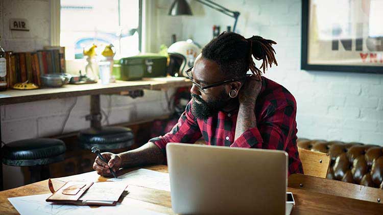 A self-employed man reviewing his business strategies at his desk.