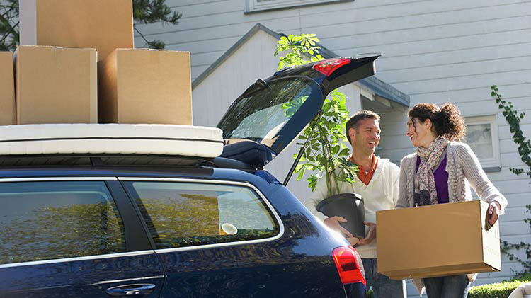 Couple loading boxes into car as they get ready to move state to state.