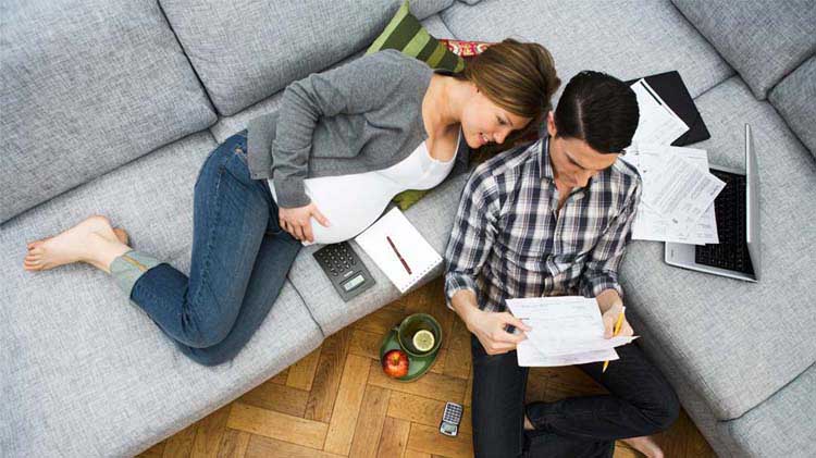 Man and woman on couch looking through contracts.