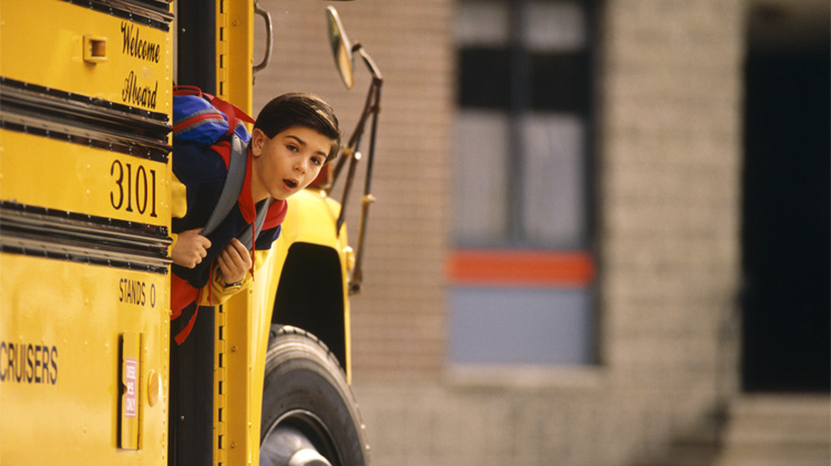 Boy using school bus safety by checking his surroundings before he exits the school bus.