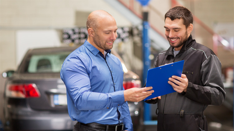 Mechanic with customer discussing car repair