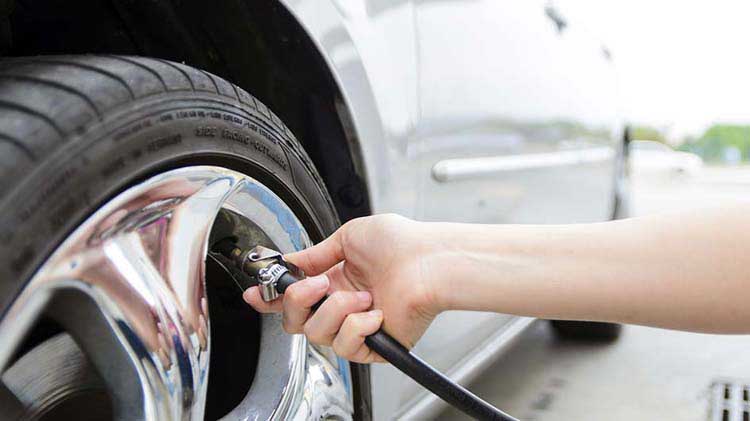 A person checking tire pressure.