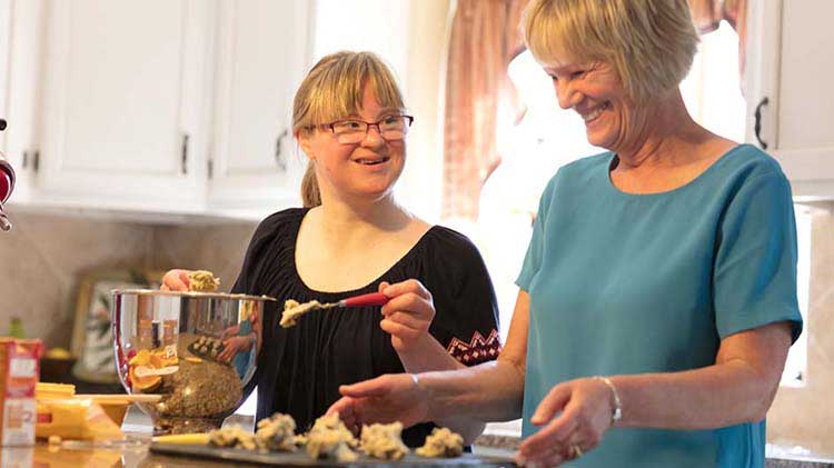 Two women baking cookies in a kitchen.