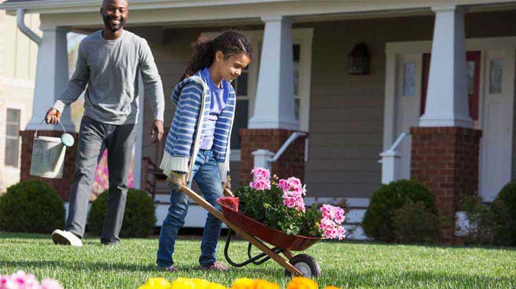 Father and daughter doing spring yard cleaning.