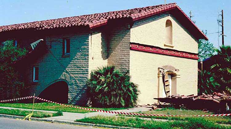 Earthquake damage to homes on a high ridge.