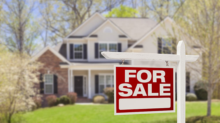 Red and white "FOR SALE" sign outside of house.